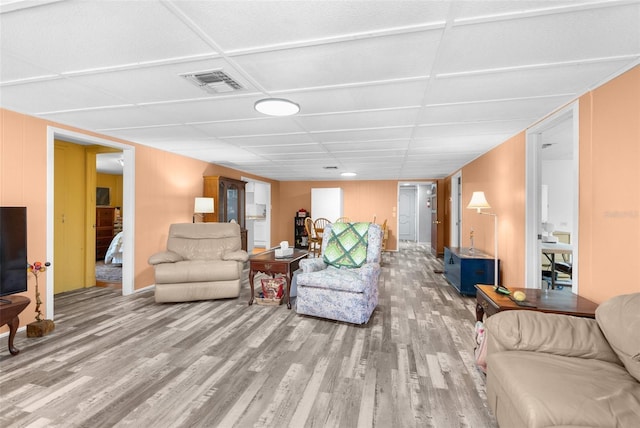 living area featuring visible vents, a paneled ceiling, and wood finished floors