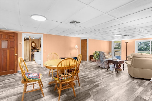 dining room with light wood-style floors, visible vents, and a drop ceiling