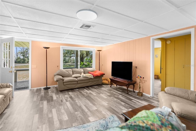 living room featuring wood finished floors, visible vents, and a drop ceiling