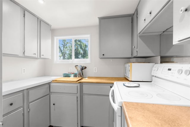 kitchen featuring white appliances, light countertops, and gray cabinetry