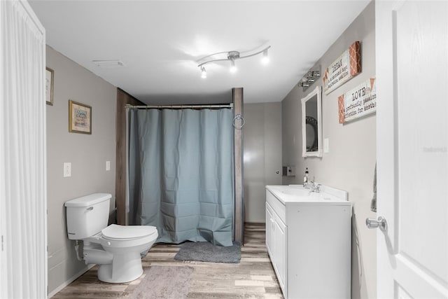 full bath with visible vents, toilet, wood finished floors, and vanity