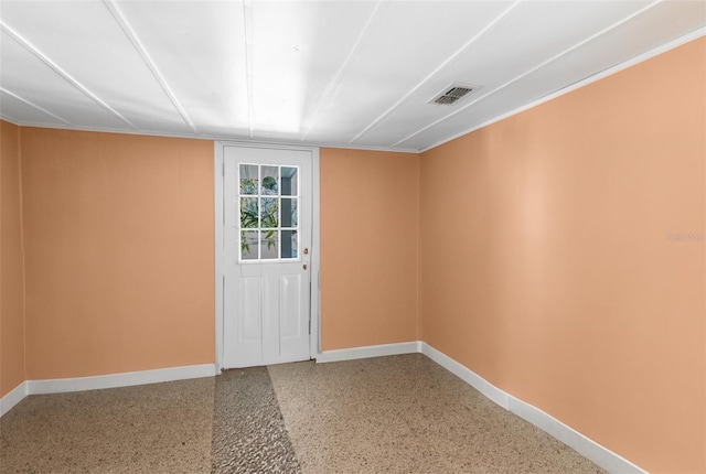 unfurnished room with speckled floor, baseboards, and visible vents