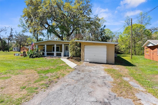 view of front of home with driveway, an attached garage, covered porch, and a front lawn