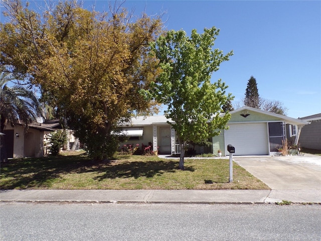 view of front of property with an attached garage, concrete driveway, and a front yard