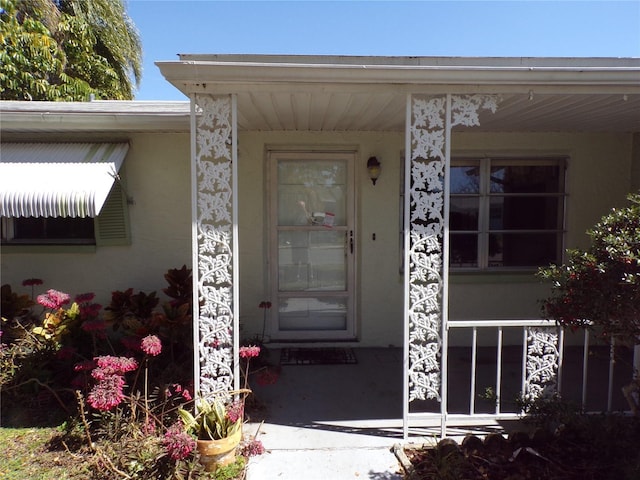 entrance to property featuring stucco siding