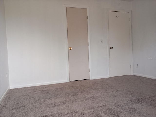 unfurnished bedroom with carpet flooring and baseboards