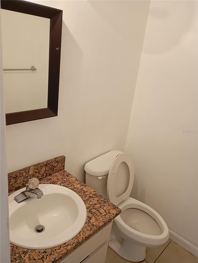 bathroom featuring tile patterned flooring, vanity, and toilet