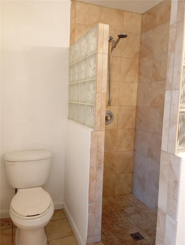 full bath with baseboards, a tile shower, toilet, and tile patterned floors