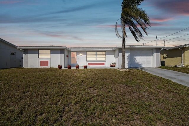 view of front facade featuring a front lawn, concrete driveway, an attached garage, and stucco siding