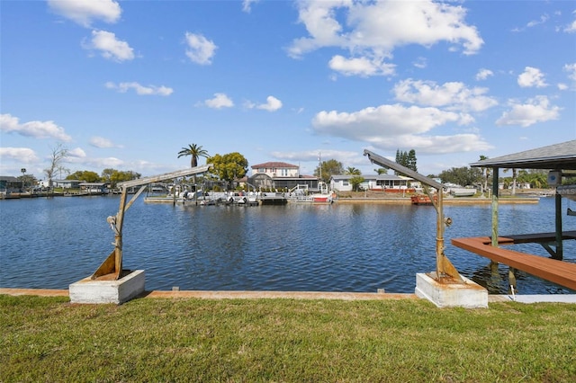 view of dock featuring a yard, a water view, and boat lift