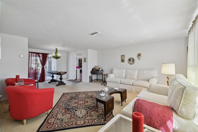 carpeted living area with a chandelier and visible vents