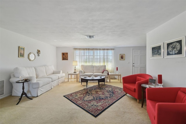 living room with a textured ceiling, visible vents, and carpet flooring