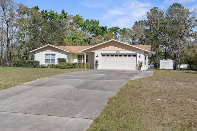 ranch-style house featuring a front yard, driveway, an attached garage, an outdoor structure, and a storage unit