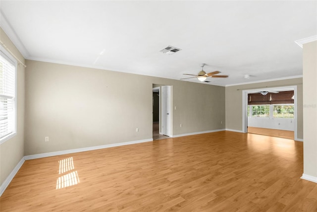 unfurnished room featuring visible vents, crown molding, baseboards, ceiling fan, and light wood-style flooring