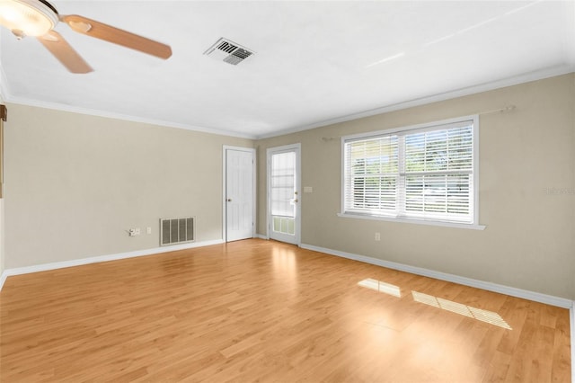 unfurnished room with light wood-type flooring, visible vents, baseboards, and ornamental molding