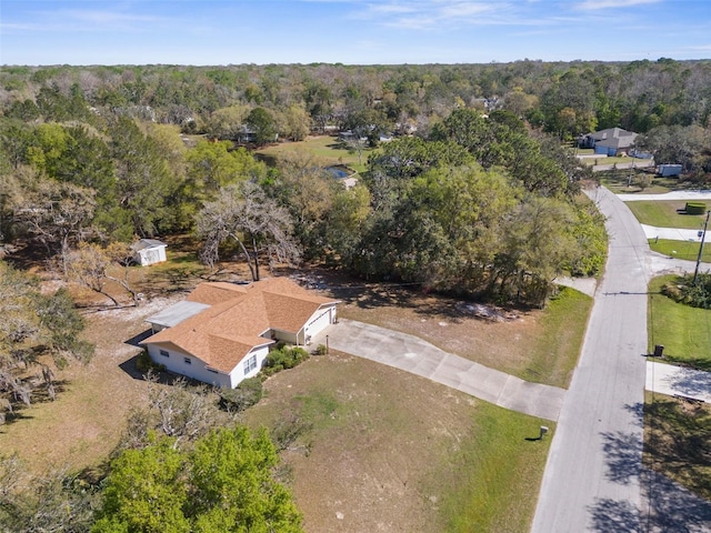 birds eye view of property featuring a view of trees