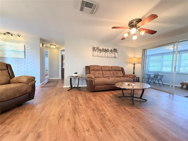living area with a ceiling fan, baseboards, visible vents, and wood finished floors