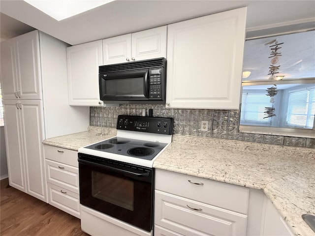 kitchen with black microwave, electric range, wood finished floors, white cabinetry, and decorative backsplash