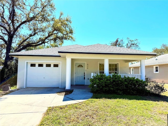 view of front of home with a garage, driveway, a front lawn, and stucco siding