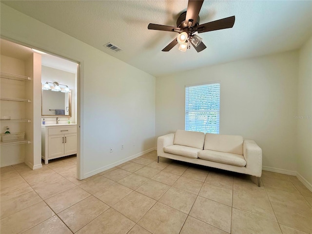 unfurnished room with visible vents, ceiling fan, a textured ceiling, and light tile patterned flooring