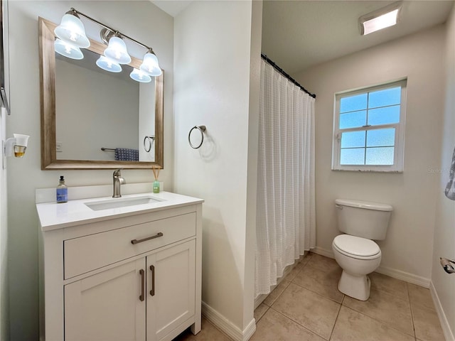 bathroom featuring toilet, vanity, a shower with curtain, baseboards, and tile patterned floors