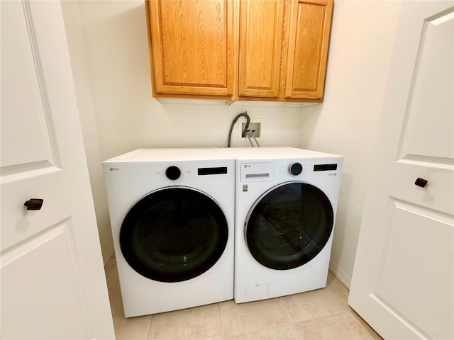 laundry room featuring cabinet space, independent washer and dryer, and light tile patterned flooring