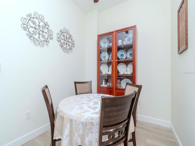 dining space featuring light wood-style floors and baseboards