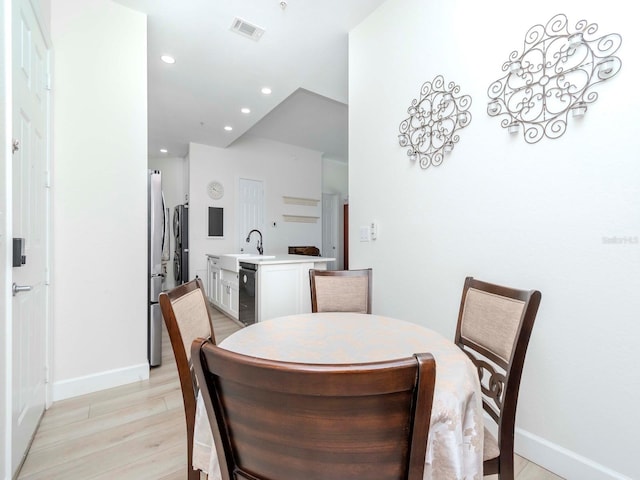 dining room with light wood-style floors, recessed lighting, visible vents, and baseboards