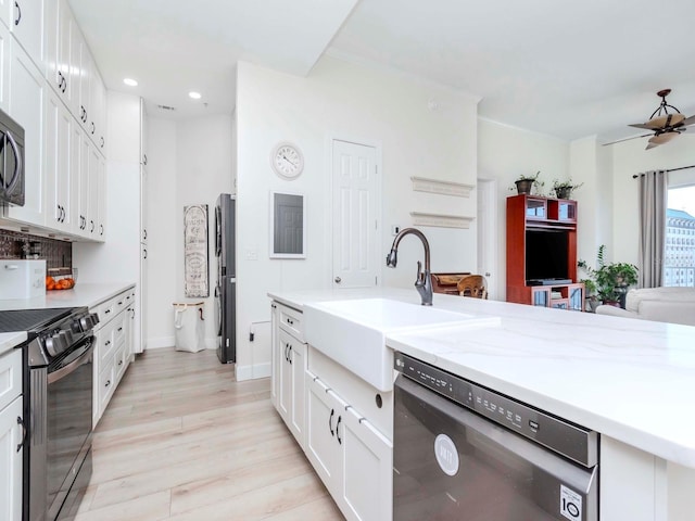 kitchen featuring white cabinetry, a sink, ceiling fan, light wood-type flooring, and black appliances