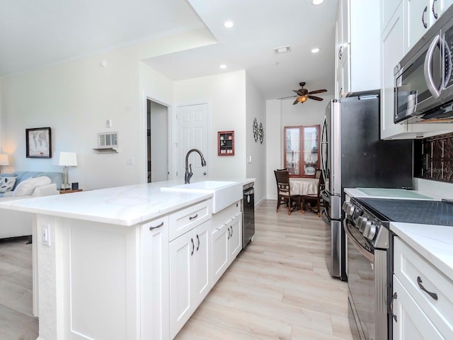 kitchen with visible vents, appliances with stainless steel finishes, white cabinetry, a sink, and recessed lighting