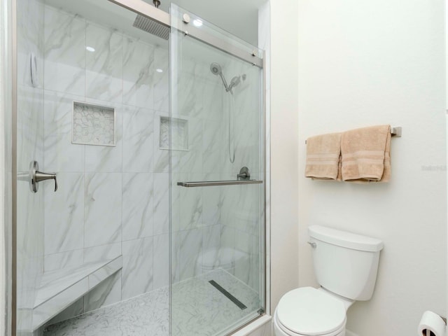 full bathroom featuring a marble finish shower and toilet