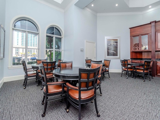 dining space with baseboards, a towering ceiling, ornamental molding, carpet, and recessed lighting