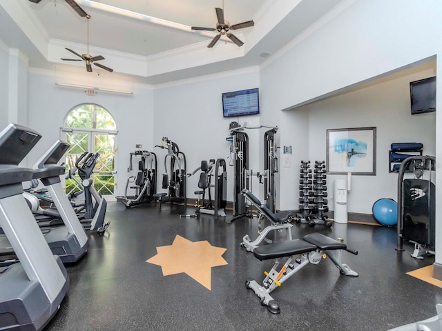 gym featuring ceiling fan, a high ceiling, a raised ceiling, and crown molding