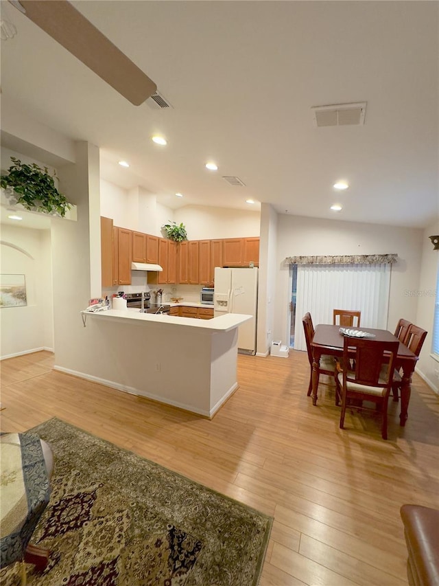 kitchen with white fridge with ice dispenser, light wood-type flooring, visible vents, and under cabinet range hood