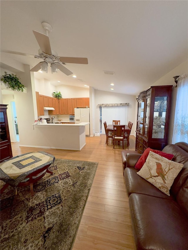 living room featuring a ceiling fan, recessed lighting, vaulted ceiling, and light wood-style flooring