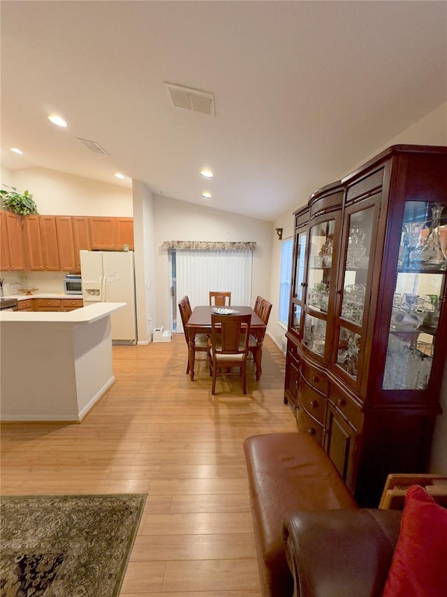 dining room featuring light wood-style floors, recessed lighting, visible vents, and vaulted ceiling