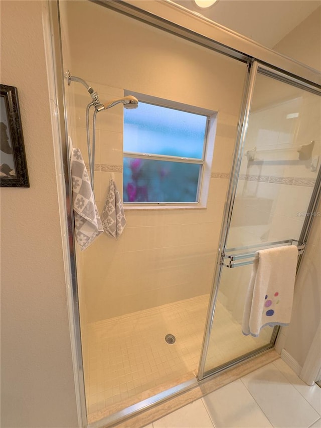 full bath with a shower stall and tile patterned floors