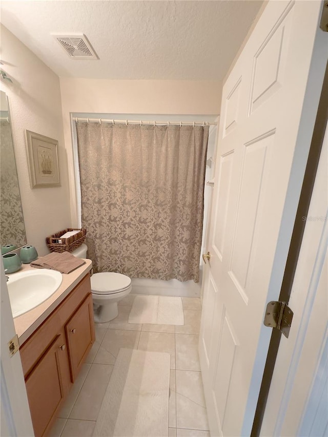 full bathroom featuring visible vents, toilet, a textured ceiling, vanity, and tile patterned flooring