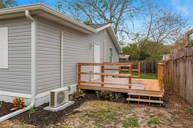 deck with ac unit and a fenced backyard