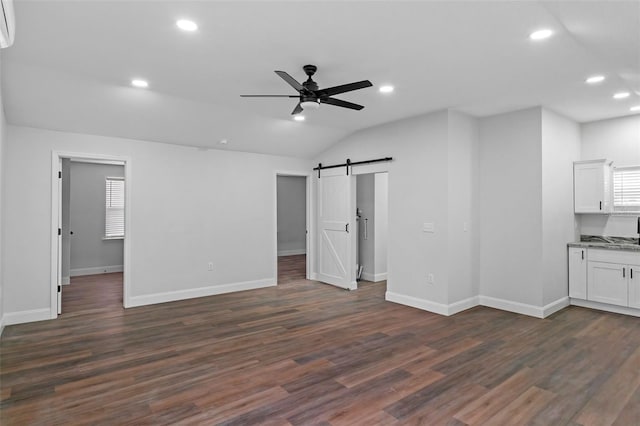 unfurnished living room featuring dark wood-style floors, recessed lighting, a barn door, ceiling fan, and baseboards