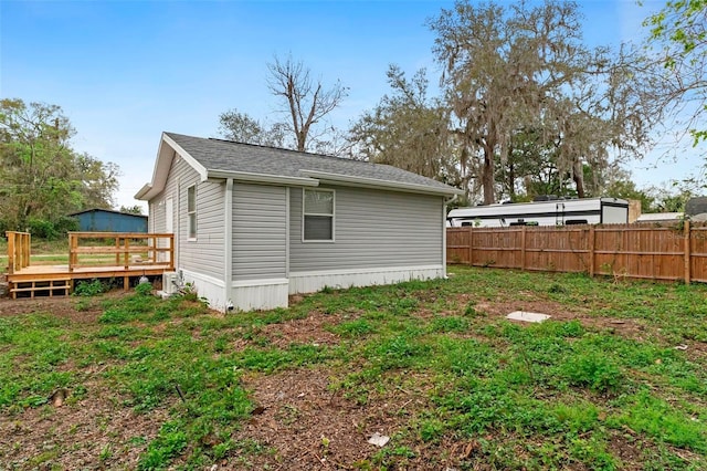 view of side of home featuring a deck and fence