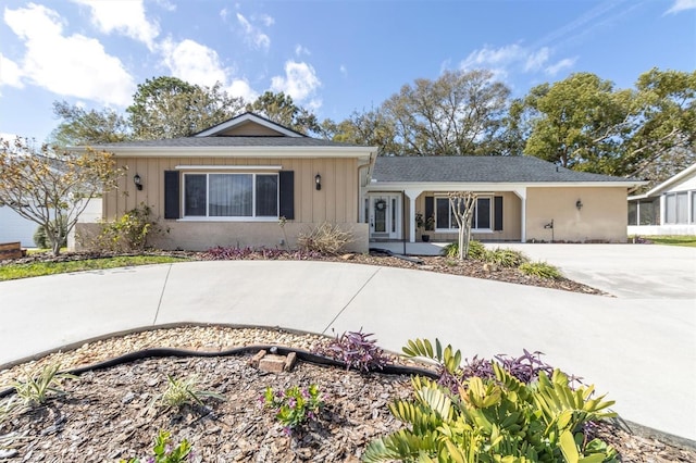 ranch-style house with concrete driveway and board and batten siding