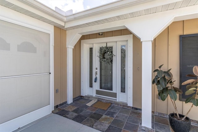 entrance to property featuring board and batten siding and an attached garage