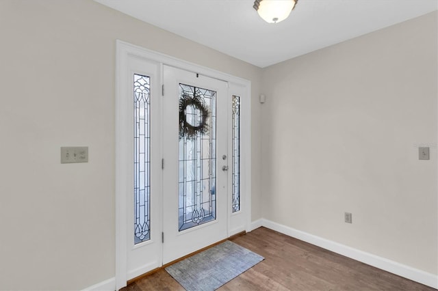 foyer featuring baseboards and wood finished floors