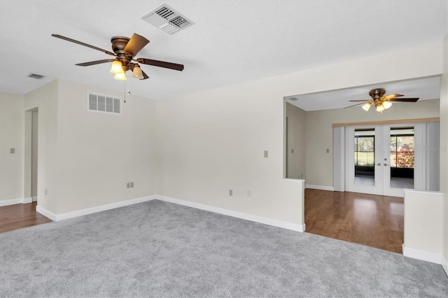 empty room with carpet floors, french doors, and visible vents