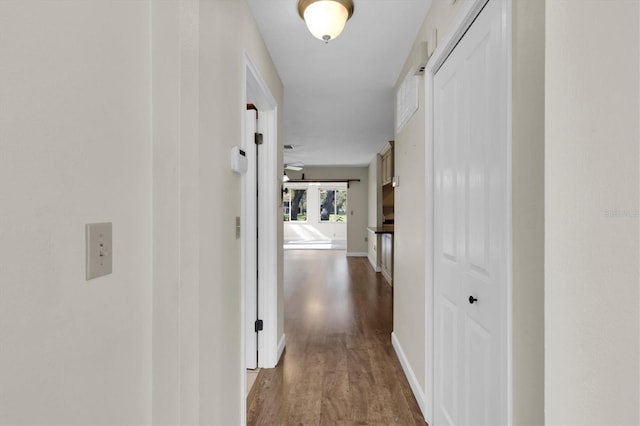 corridor featuring wood finished floors and baseboards