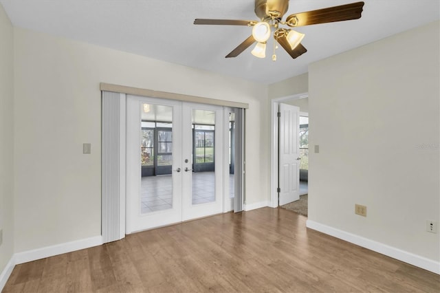 unfurnished room with french doors, wood finished floors, a wealth of natural light, and baseboards