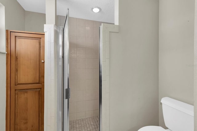 bathroom with a shower stall and toilet