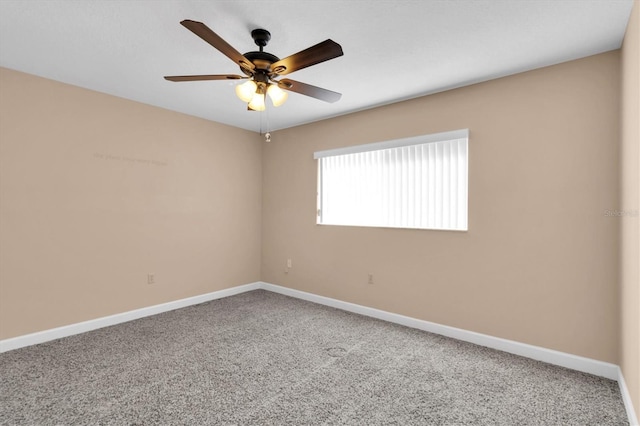 carpeted spare room with baseboards and a ceiling fan