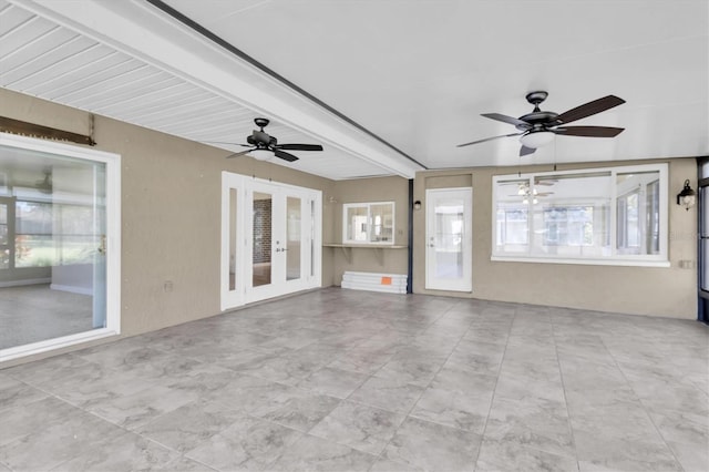 interior space with ceiling fan, beamed ceiling, and french doors